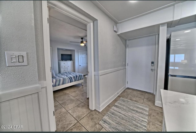 entrance foyer featuring light tile patterned floors and ceiling fan