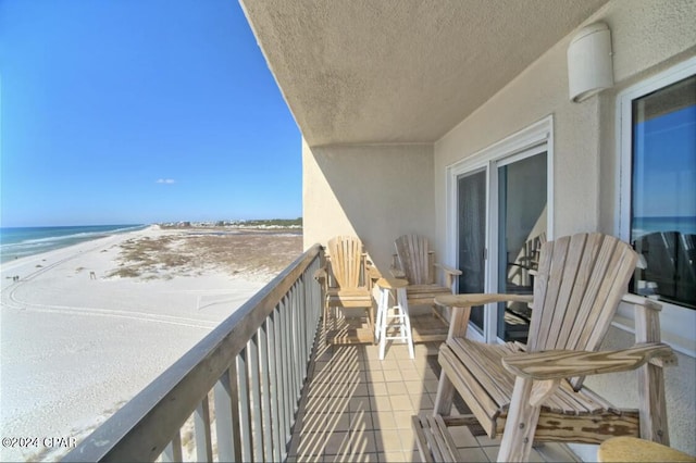 balcony featuring a water view and a view of the beach