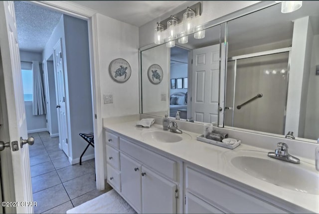 bathroom featuring tile patterned floors, vanity, and a textured ceiling