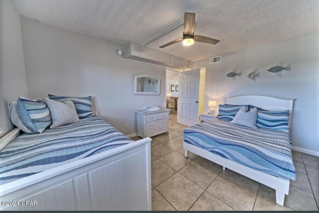 tiled bedroom featuring a textured ceiling and ceiling fan