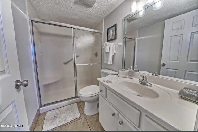 bathroom featuring vanity, tile patterned flooring, toilet, a textured ceiling, and an enclosed shower