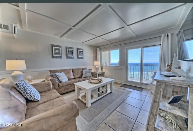 living room featuring a water view and light tile patterned floors