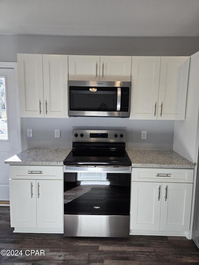 kitchen featuring white cabinets, dark hardwood / wood-style flooring, light stone countertops, and appliances with stainless steel finishes