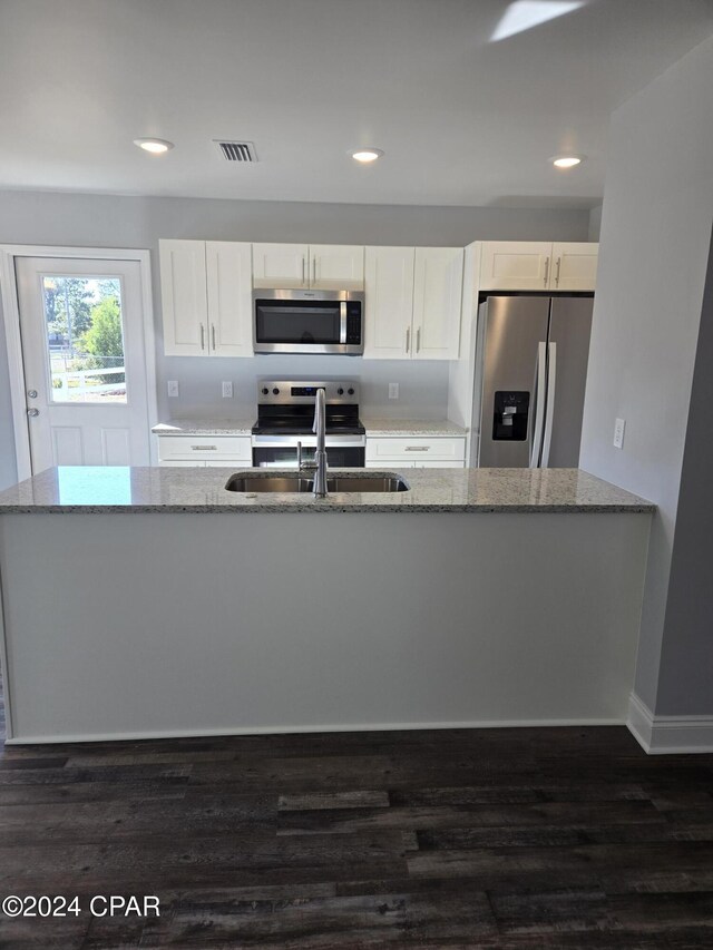 kitchen with white cabinetry, sink, stainless steel appliances, an inviting chandelier, and light stone counters