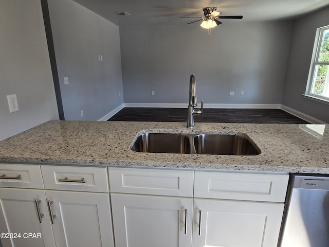 kitchen featuring ceiling fan, dishwasher, sink, light stone counters, and white cabinets