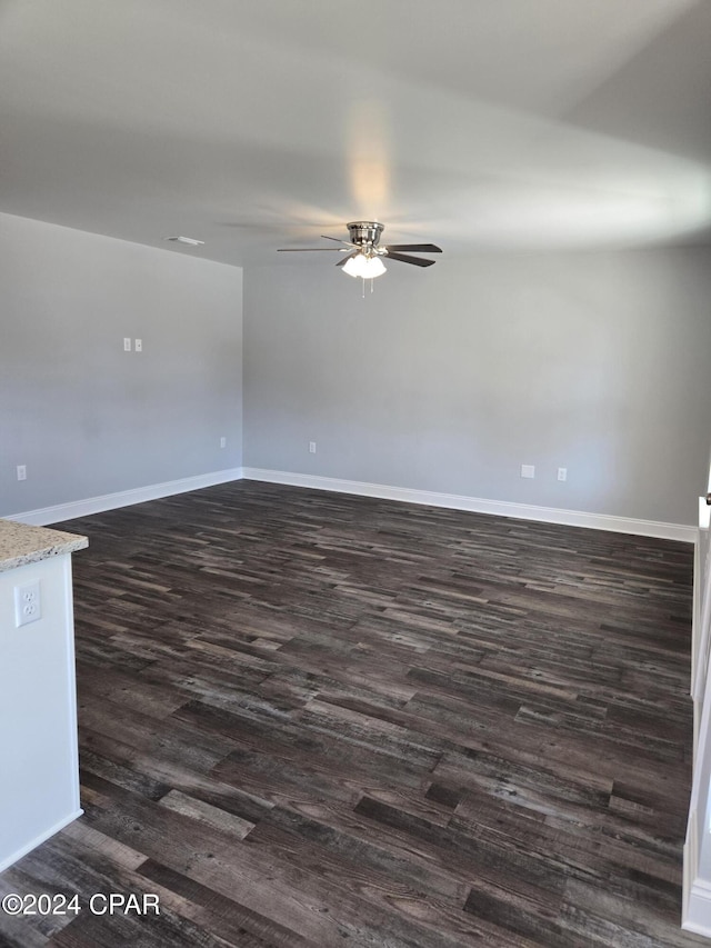 empty room with dark hardwood / wood-style floors and ceiling fan