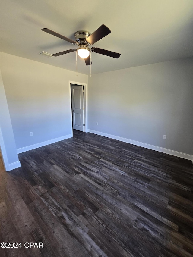 spare room featuring dark hardwood / wood-style flooring and ceiling fan