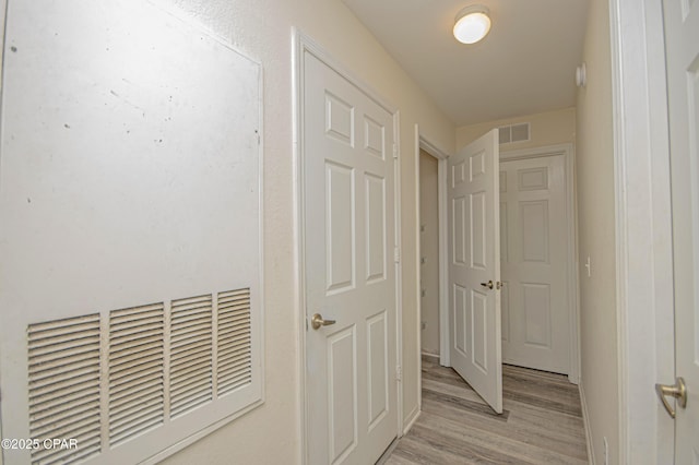 corridor featuring light wood-style floors and visible vents
