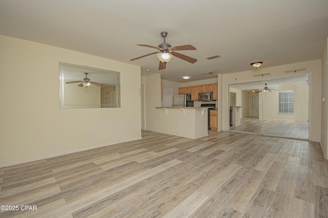 unfurnished living room with light wood finished floors, a ceiling fan, and visible vents