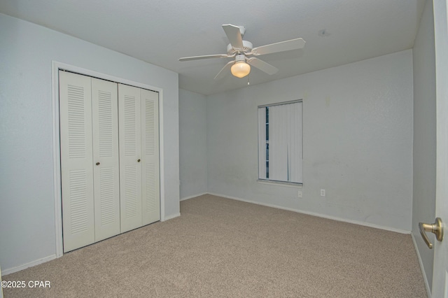 unfurnished bedroom featuring a closet, baseboards, a ceiling fan, and carpet flooring