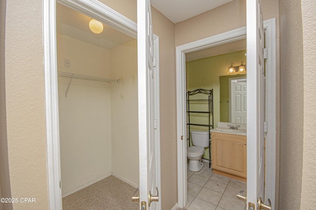 interior space with tile patterned flooring, toilet, and vanity