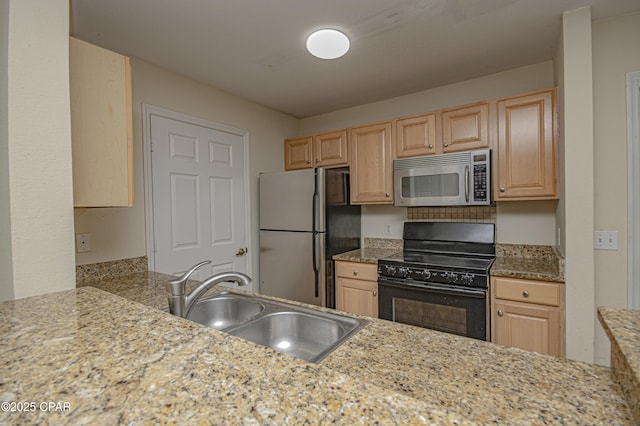 kitchen featuring a sink, appliances with stainless steel finishes, and light brown cabinetry