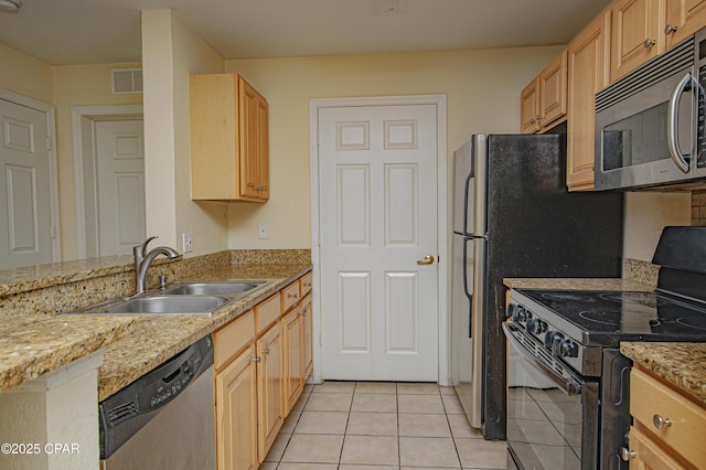 kitchen featuring light tile patterned floors, light brown cabinetry, visible vents, a sink, and stainless steel appliances