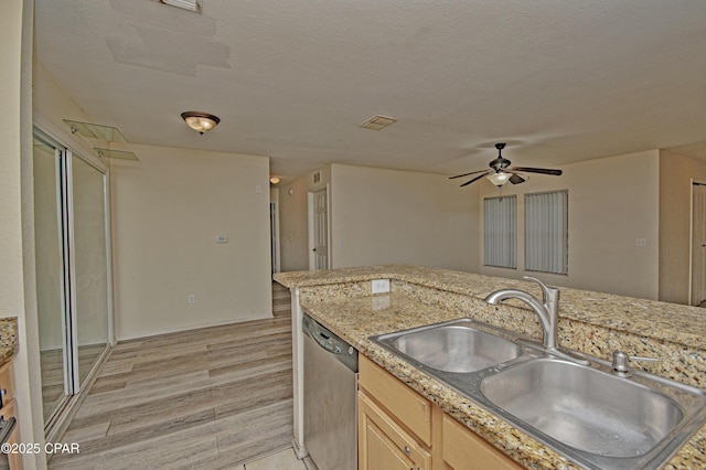 kitchen featuring a ceiling fan, light wood-style floors, stainless steel dishwasher, a sink, and light brown cabinetry