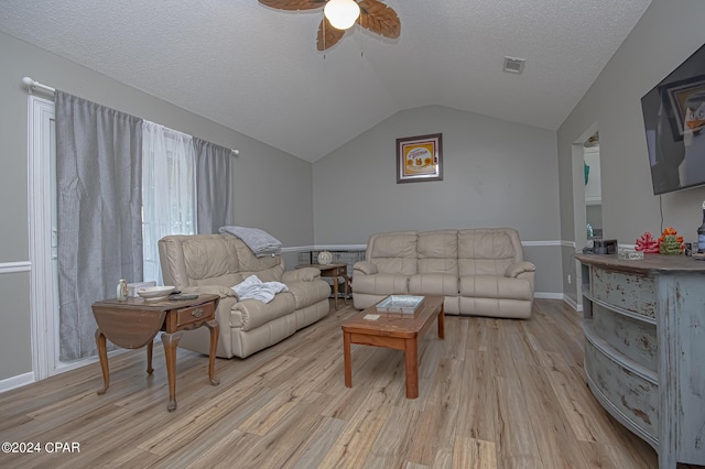 living room featuring ceiling fan, lofted ceiling, a textured ceiling, and light wood-type flooring