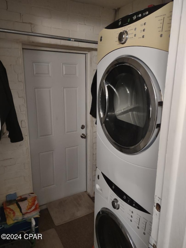 washroom featuring stacked washer and clothes dryer