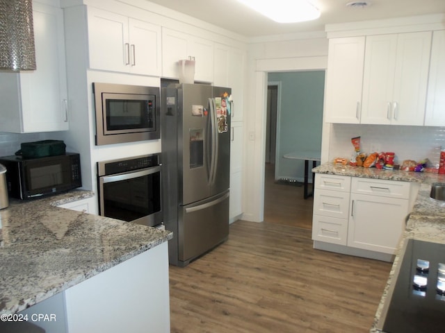 kitchen featuring white cabinets, dark hardwood / wood-style flooring, light stone countertops, and stainless steel appliances