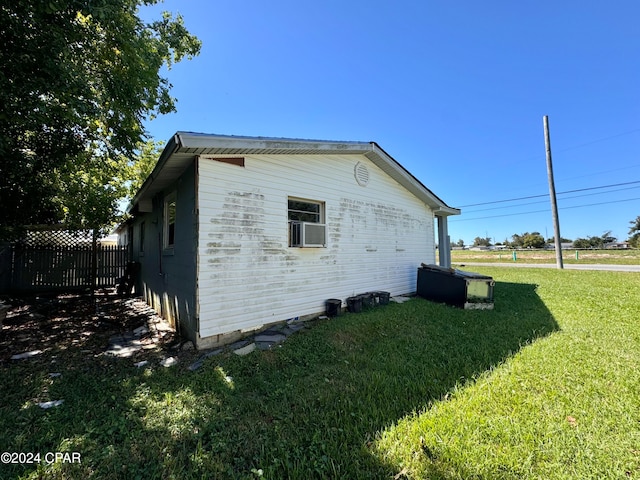 view of side of property with a yard and cooling unit