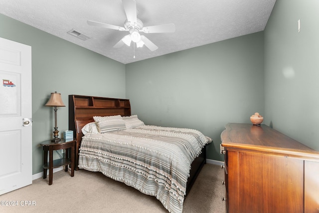 carpeted bedroom featuring a textured ceiling and ceiling fan