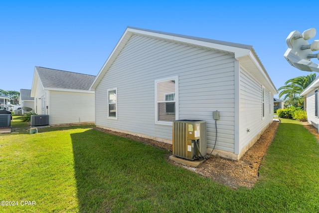 rear view of house with a yard and central AC