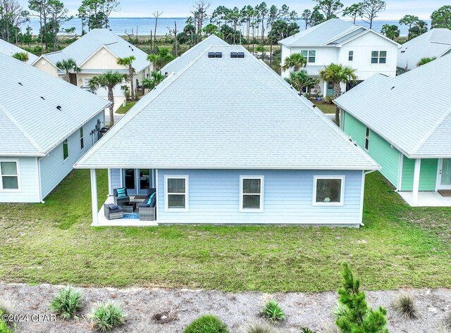 back of property featuring a patio area, a lawn, and an outdoor hangout area