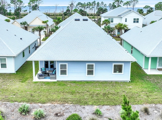 rear view of property featuring outdoor lounge area, a patio area, and a lawn