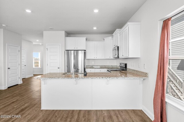 kitchen with dark wood-type flooring, appliances with stainless steel finishes, and white cabinets