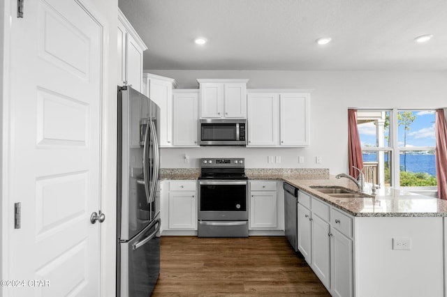 kitchen featuring light stone countertops, sink, kitchen peninsula, white cabinetry, and stainless steel appliances