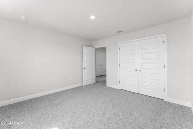 unfurnished bedroom featuring carpet floors and a closet