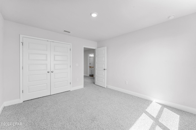 unfurnished bedroom featuring a closet and carpet flooring