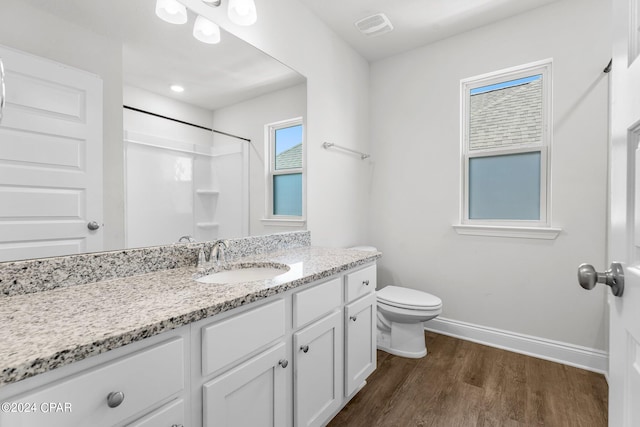 bathroom with vanity, toilet, a shower, and wood-type flooring