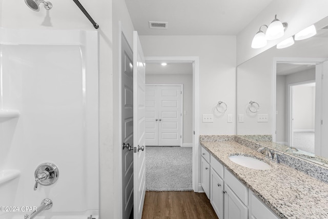 bathroom with vanity, hardwood / wood-style flooring, and bathing tub / shower combination