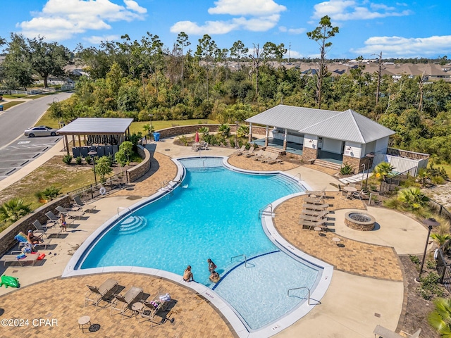 view of swimming pool with an outdoor fire pit and a patio