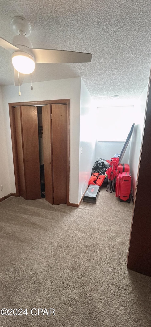 bedroom featuring ceiling fan, a closet, carpet, and a textured ceiling