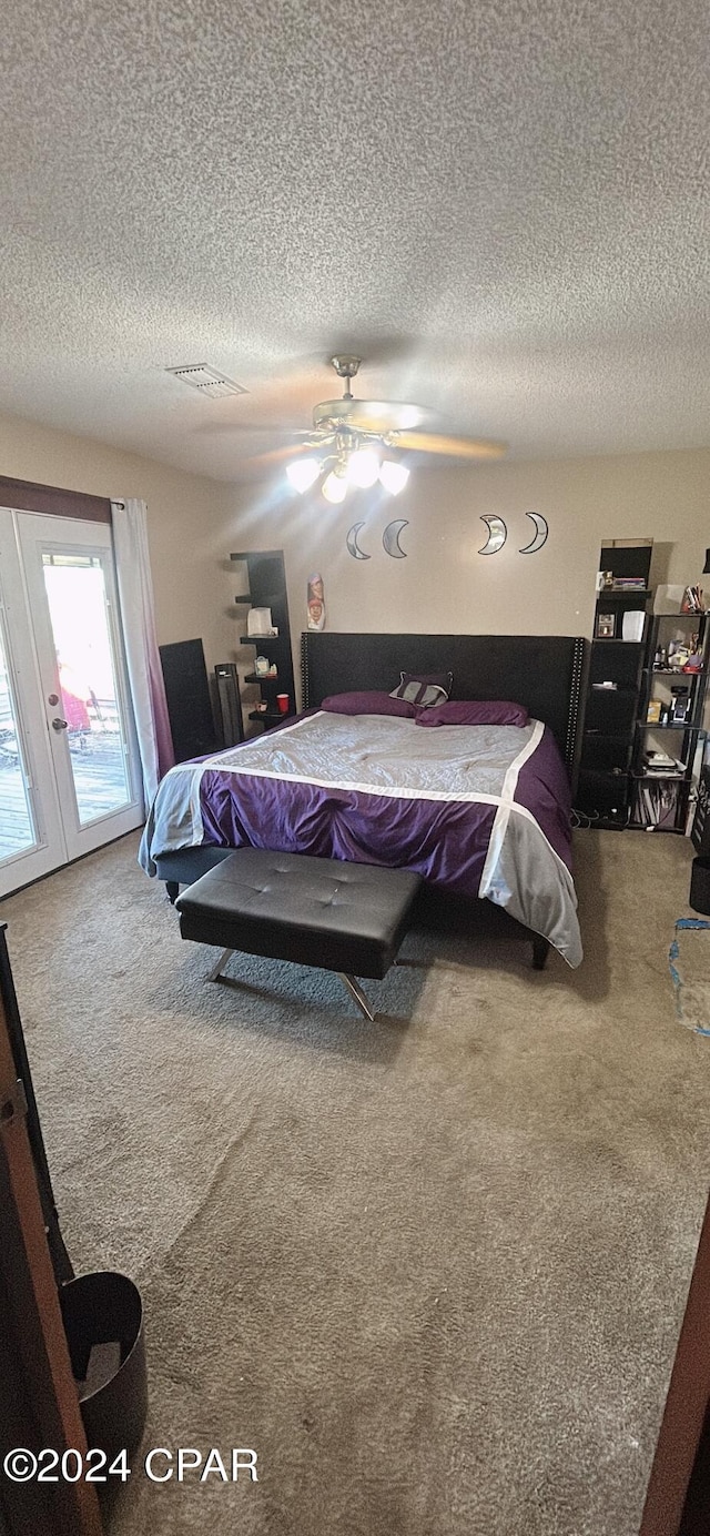 bedroom featuring carpet flooring, a textured ceiling, and ceiling fan