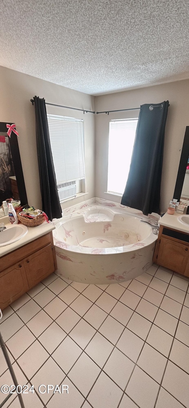 bathroom featuring a bathing tub, tile patterned flooring, vanity, and a textured ceiling