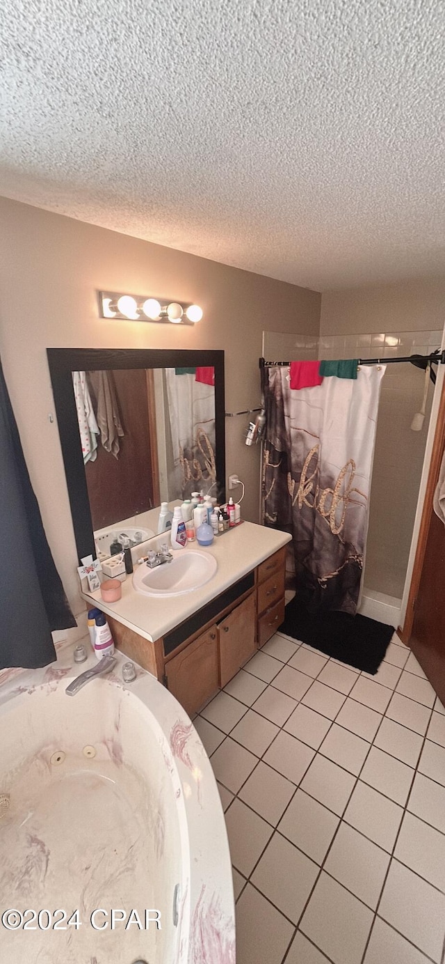 bathroom with tile patterned floors, plus walk in shower, vanity, and a textured ceiling