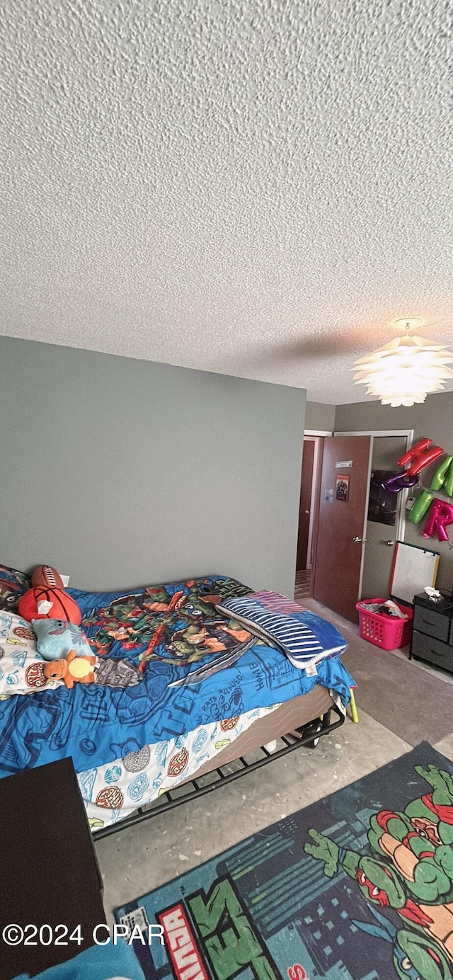 bedroom with concrete flooring and a textured ceiling