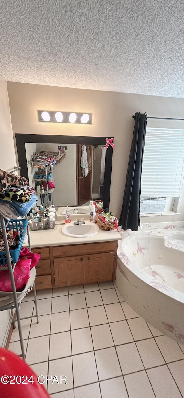 bathroom featuring tile patterned floors, a bathtub, a textured ceiling, and vanity