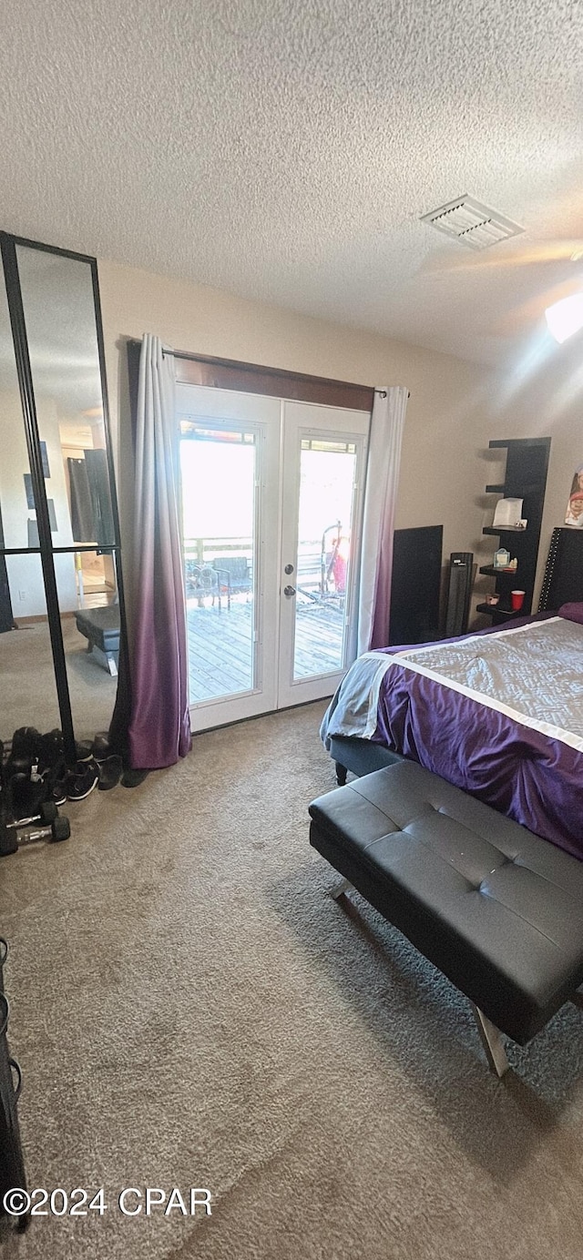 carpeted bedroom with access to exterior, french doors, and a textured ceiling