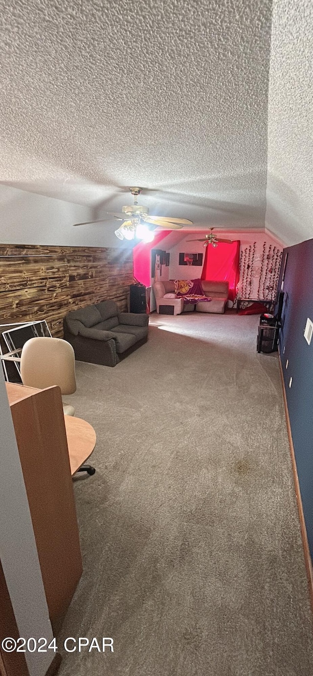 recreation room with carpet flooring, ceiling fan, a textured ceiling, and vaulted ceiling