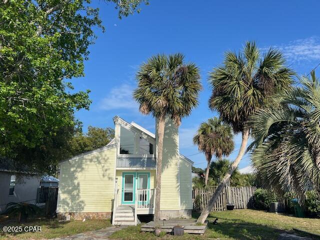 view of home's exterior featuring fence and a lawn