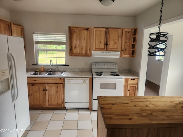 kitchen featuring butcher block counters, sink, light tile patterned floors, pendant lighting, and white appliances