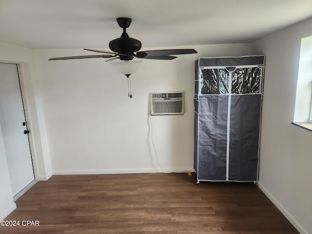 unfurnished bedroom with an AC wall unit, dark hardwood / wood-style flooring, and ceiling fan