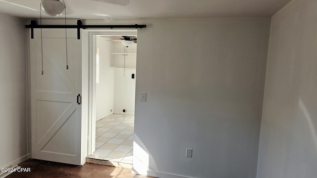 hall featuring a barn door and tile patterned flooring