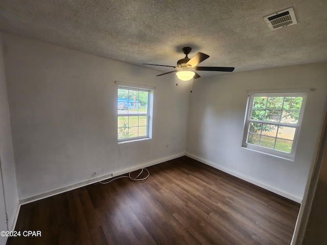 empty room featuring dark hardwood / wood-style flooring, a textured ceiling, and ceiling fan