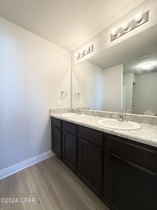 bathroom featuring a shower, hardwood / wood-style floors, a textured ceiling, and toilet