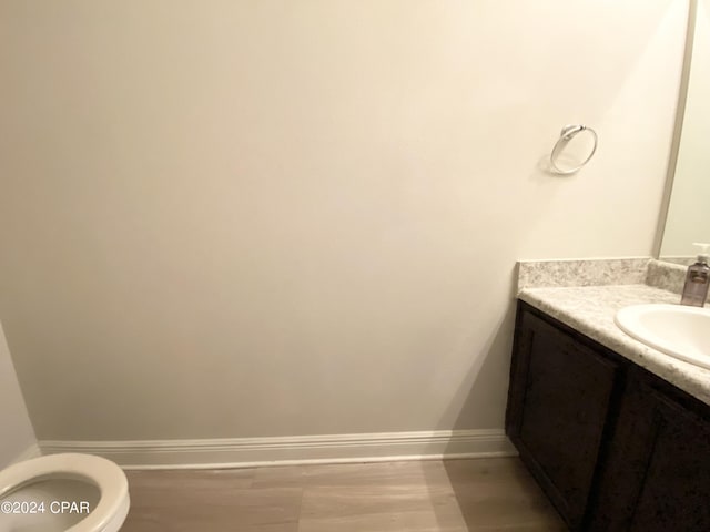 bathroom featuring vanity, hardwood / wood-style flooring, and toilet