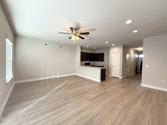 unfurnished living room featuring ceiling fan and light hardwood / wood-style floors