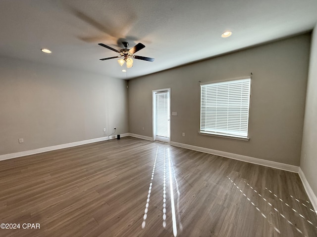 empty room with ceiling fan, a textured ceiling, and hardwood / wood-style flooring